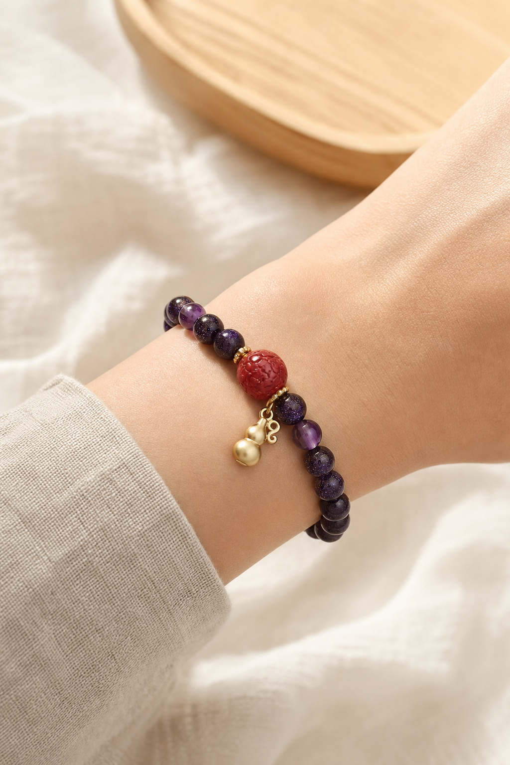 Cinnabar and amethyst bracelet worn on wrist in natural light